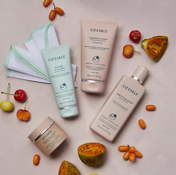 Four Liz Earle products photographed alongside fruits